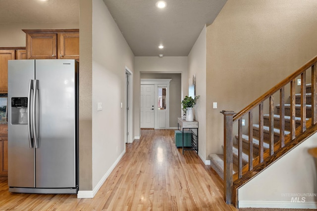 entryway with light wood-style flooring, recessed lighting, baseboards, and stairs