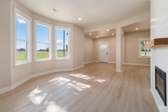 4320 SW 2nd Ave, New Plymouth, ID 83655 - unfurnished living room featuring a glass covered fireplace, light wood-type flooring, and recessed lighting