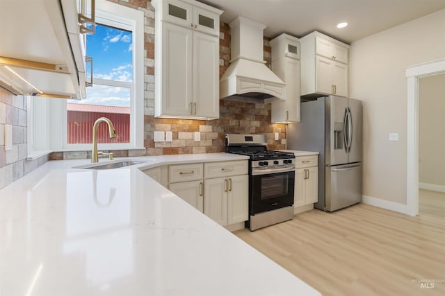 4320 SW 2nd Ave, New Plymouth, ID 83655 - kitchen with stainless steel appliances, custom exhaust hood, decorative backsplash, light wood-style floors, and glass insert cabinets