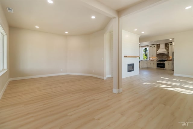 4320 SW 2nd Ave, New Plymouth, ID 83655 - unfurnished living room with a large fireplace, light wood-style flooring, recessed lighting, and beam ceiling