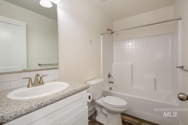 full bathroom featuring toilet, washtub / shower combination, backsplash, vanity, and hardwood / wood-style flooring