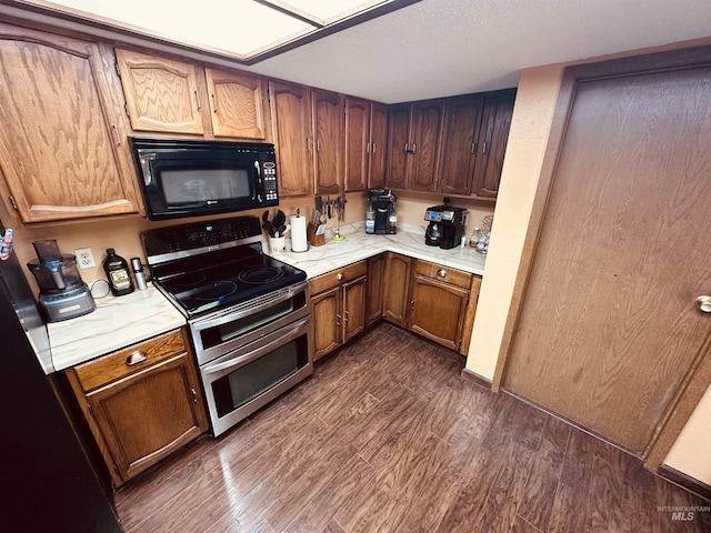 245 W 3rd St, Huntington, OR 97907 - kitchen featuring black microwave, range with two ovens, light countertops, and dark wood-type flooring