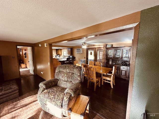 245 W 3rd St, Huntington, OR 97907 - living room with wood finished floors, a ceiling fan, a textured ceiling, a textured wall, and an AC wall unit