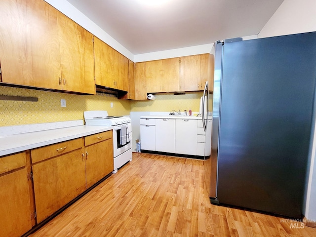102 N Hornet Creek Rd, Council, ID 83612 - kitchen featuring freestanding refrigerator, white electric range oven, light wood-type flooring, light countertops, and under cabinet range hood
