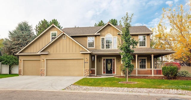 view of front of house with driveway, covered porch, board and batten siding, and a front yard