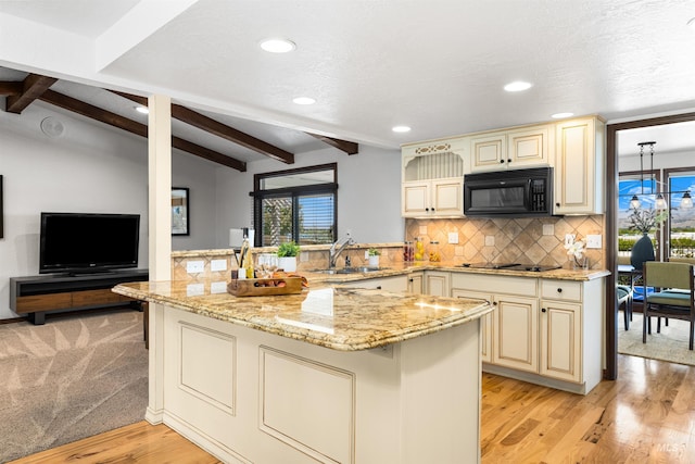 kitchen with cream cabinetry, black appliances, a sink, healthy amount of natural light, and recessed lighting