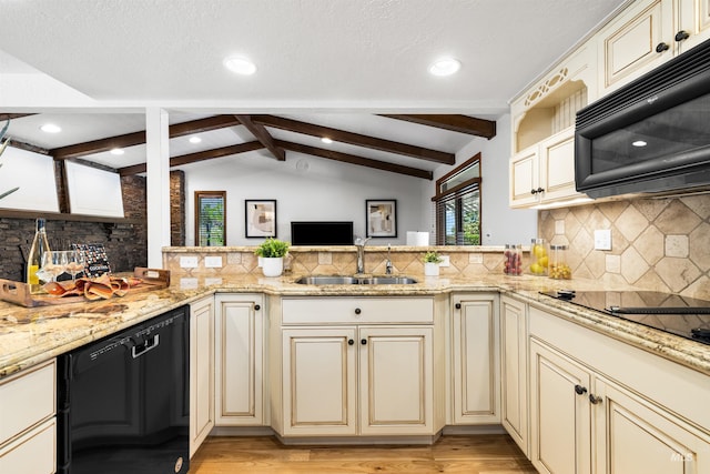 kitchen with cream cabinetry, black appliances, a sink, a peninsula, and recessed lighting