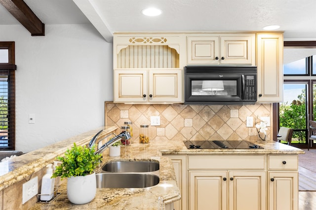 kitchen with cream cabinets, black appliances, a sink, decorative backsplash, and beam ceiling