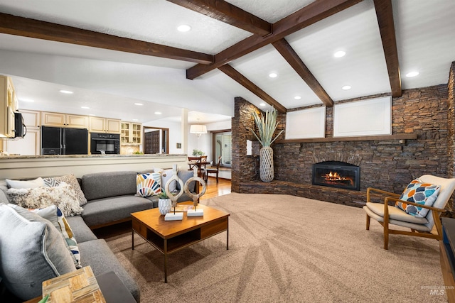 living area featuring a stone fireplace and recessed lighting