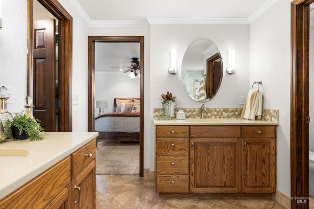 full bath featuring crown molding, ensuite bathroom, ceiling fan, and two vanities
