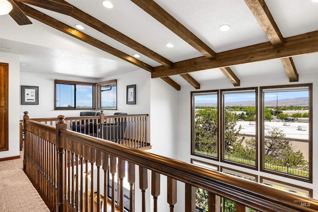 hall featuring beamed ceiling, recessed lighting, healthy amount of natural light, an upstairs landing, and carpet floors