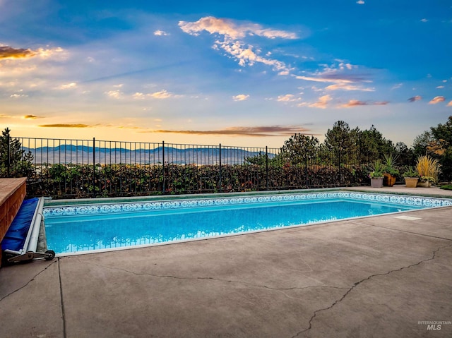 view of swimming pool featuring fence and a patio area