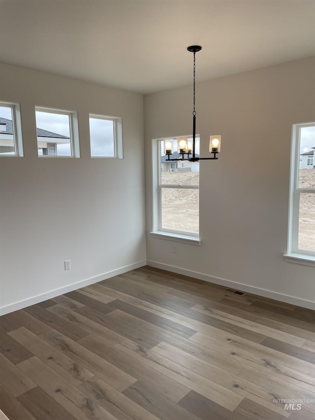 1207 Frank Henry Rd, Twin Falls, ID 83301 - empty room featuring a chandelier, wood finished floors, and healthy amount of natural light