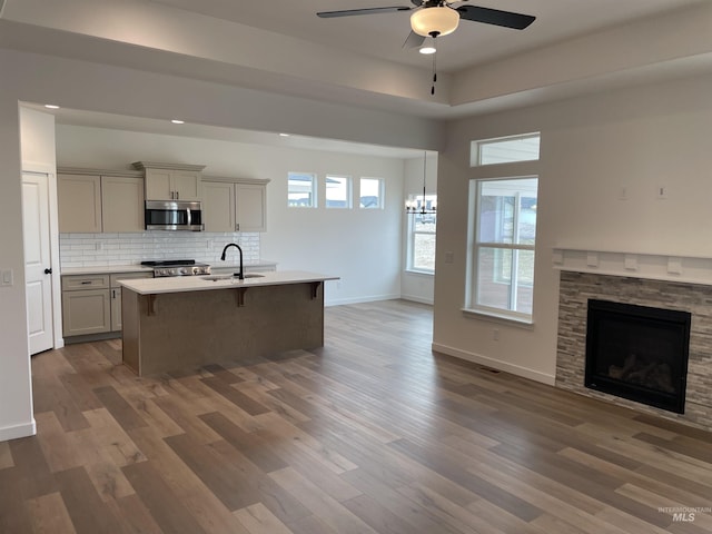 1207 Frank Henry Rd, Twin Falls, ID 83301 - kitchen with stainless steel microwave, open floor plan, a sink, a ceiling fan, and a kitchen bar