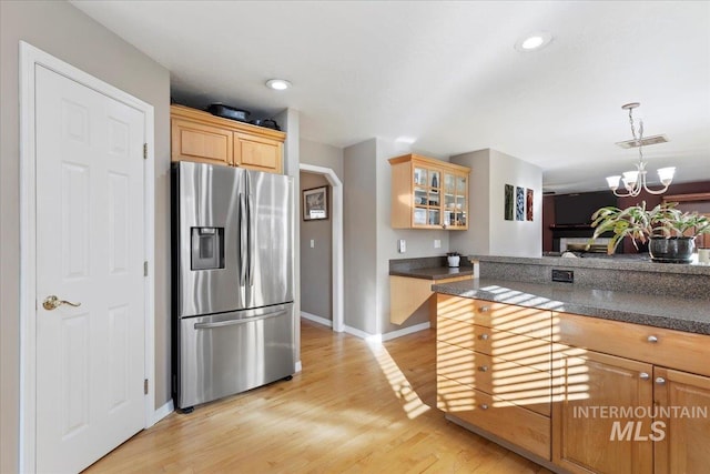 kitchen with a notable chandelier, stainless steel fridge with ice dispenser, decorative light fixtures, light wood-type flooring, and light brown cabinets