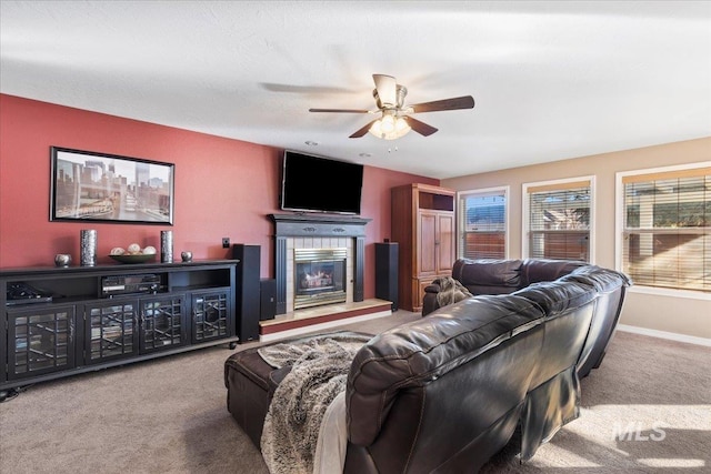 carpeted living room with ceiling fan and a fireplace