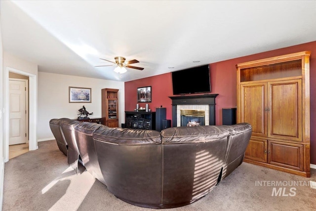 carpeted living room with a fireplace and ceiling fan