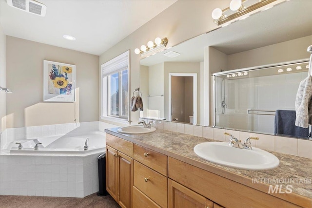 bathroom featuring vanity and independent shower and bath