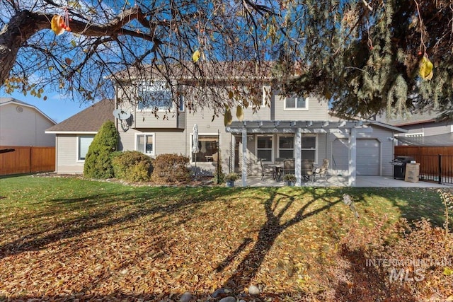 back of property with a yard, a pergola, and a patio