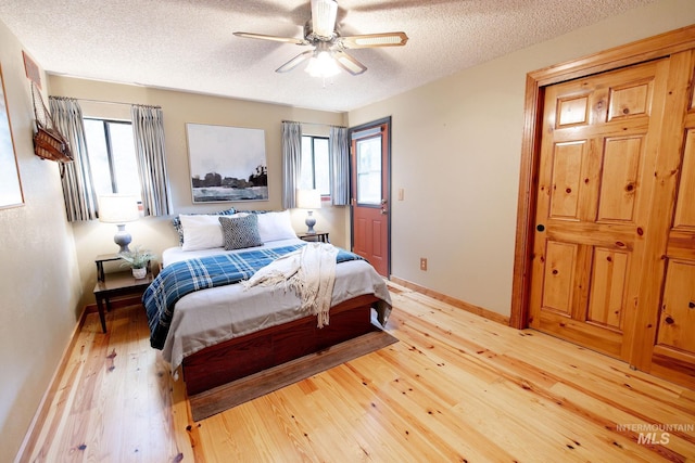 1955 E Parkside Dr, Boise, ID 83712 - bedroom featuring light wood finished floors, a textured ceiling, multiple windows, baseboards, and ceiling fan