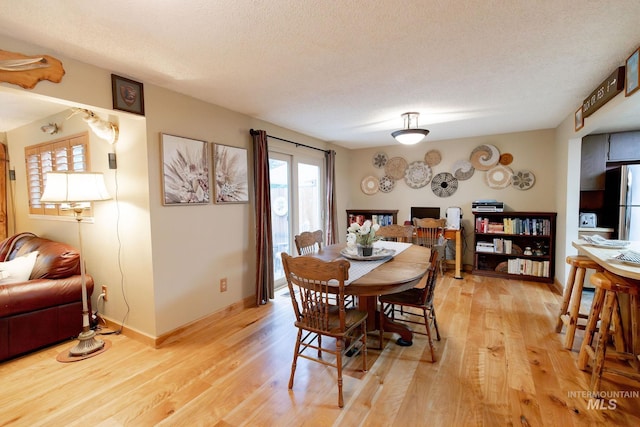 1955 E Parkside Dr, Boise, ID 83712 - dining area featuring light wood-type flooring, baseboards, and a textured ceiling