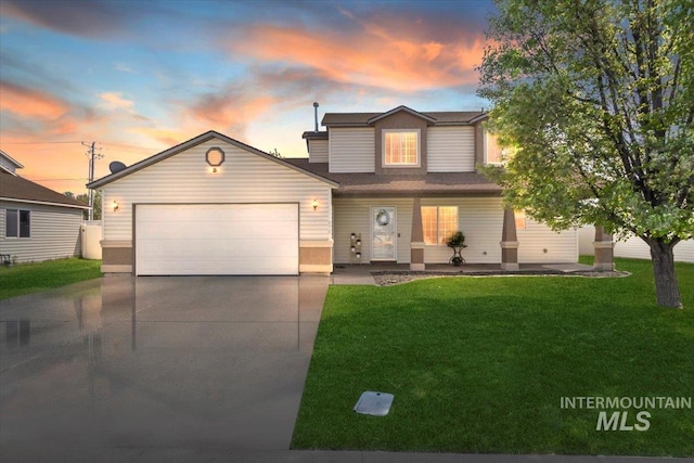 view of front of property featuring driveway, a garage, and a front lawn