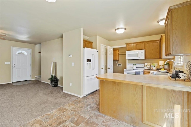 kitchen with white appliances, a sink, a peninsula, light countertops, and baseboards