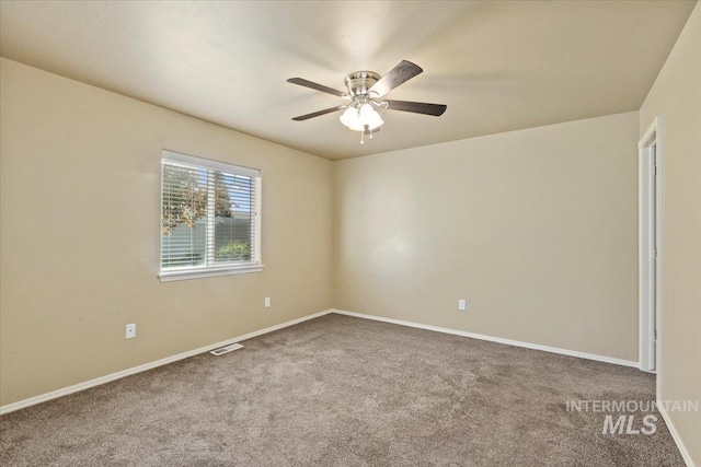 empty room with carpet floors, a ceiling fan, and baseboards