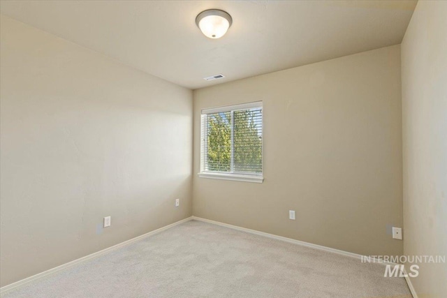 unfurnished room featuring light colored carpet and baseboards