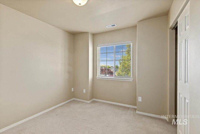 empty room with light carpet and baseboards