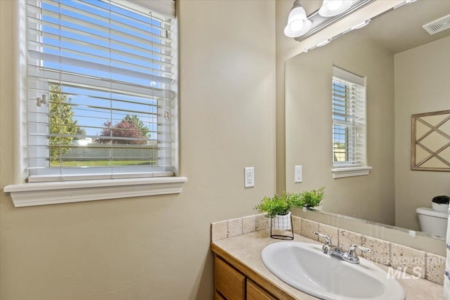 half bathroom with vanity and toilet