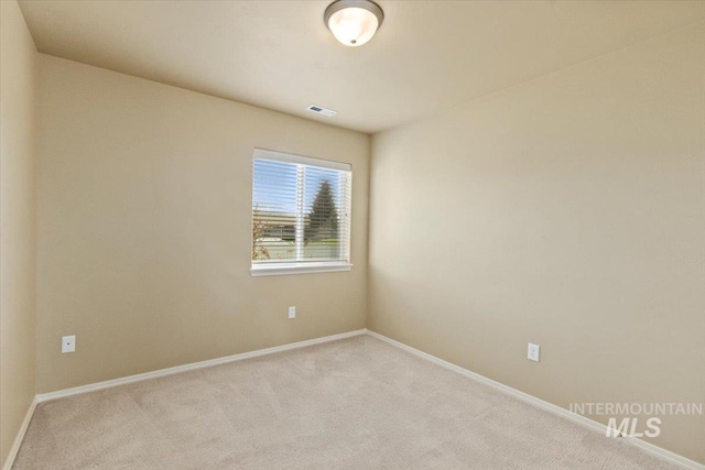 carpeted spare room featuring baseboards