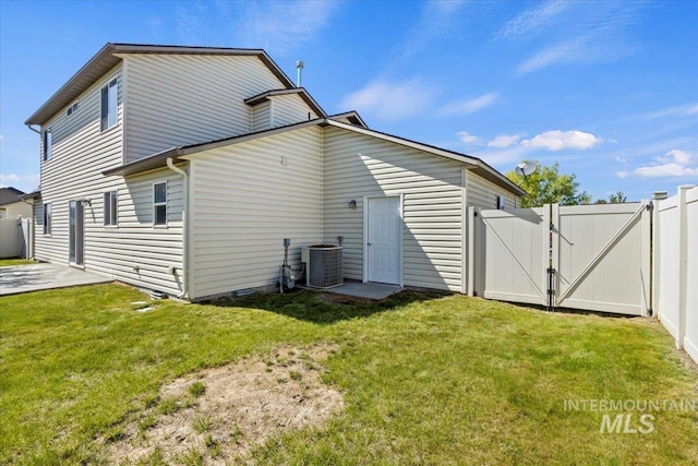 rear view of house with a gate and central AC