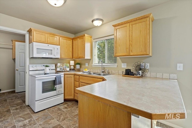 kitchen with white appliances, a sink, a peninsula, light countertops, and light brown cabinetry
