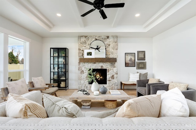 living room featuring a fireplace, beamed ceiling, recessed lighting, and wood finished floors