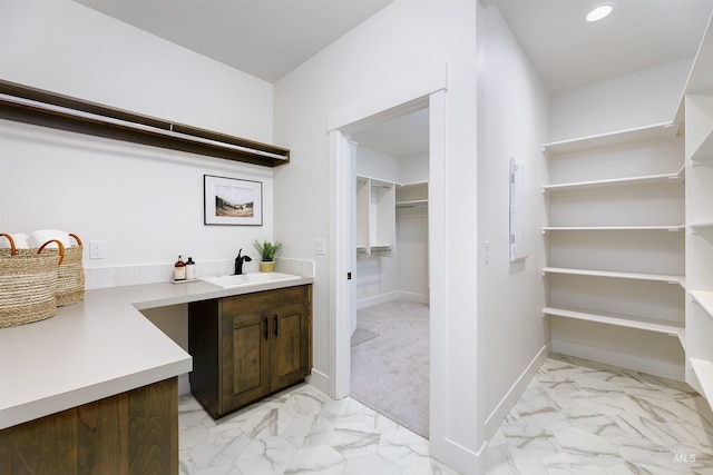 interior space featuring a sink, baseboards, marble finish floor, and recessed lighting