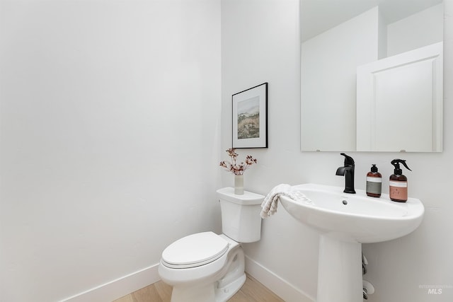 bathroom featuring baseboards and toilet