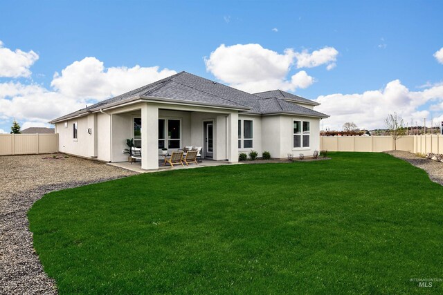 back of house featuring a patio, roof with shingles, a fenced backyard, stucco siding, and a lawn