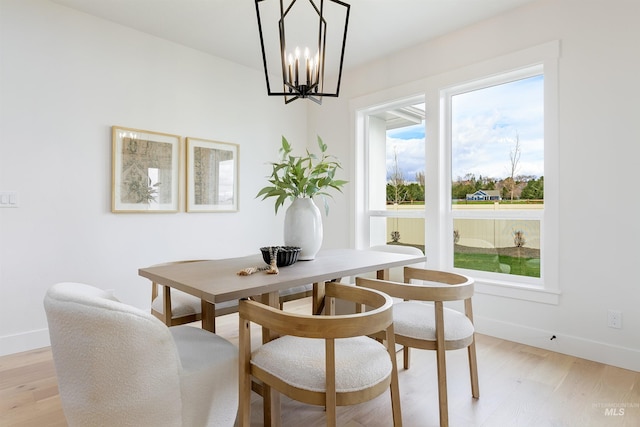 dining room with breakfast area, baseboards, and light wood-style floors