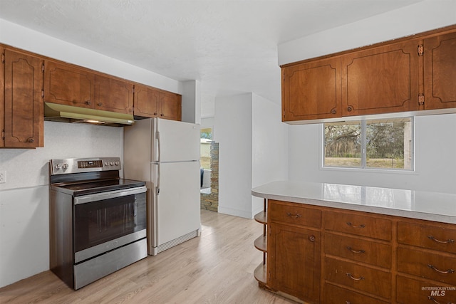 1006 S B St, Rupert, ID 83350 - kitchen with stainless steel electric range oven, under cabinet range hood, freestanding refrigerator, light wood finished floors, and light countertops