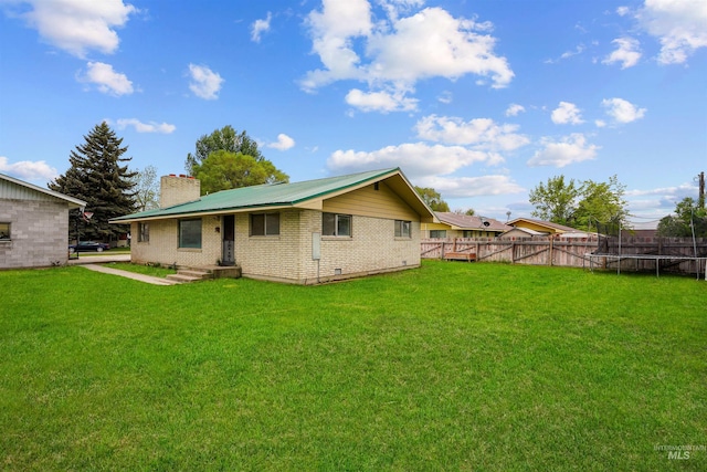 1006 S B St, Rupert, ID 83350 - rear view of property featuring a trampoline, a chimney, brick siding, and crawl space