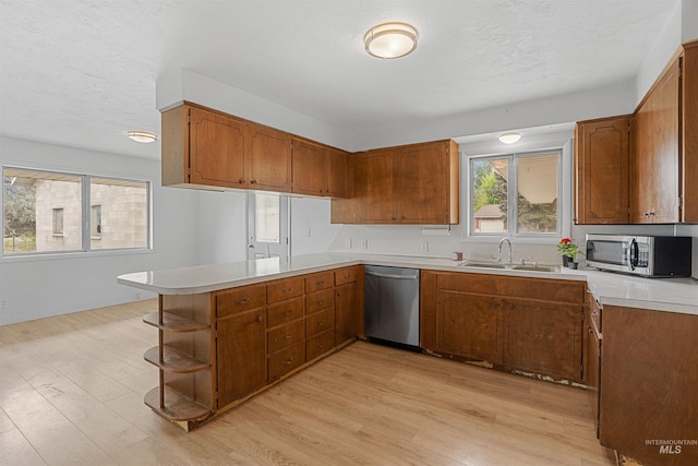 1006 S B St, Rupert, ID 83350 - kitchen with appliances with stainless steel finishes, a sink, a peninsula, brown cabinetry, and a textured ceiling