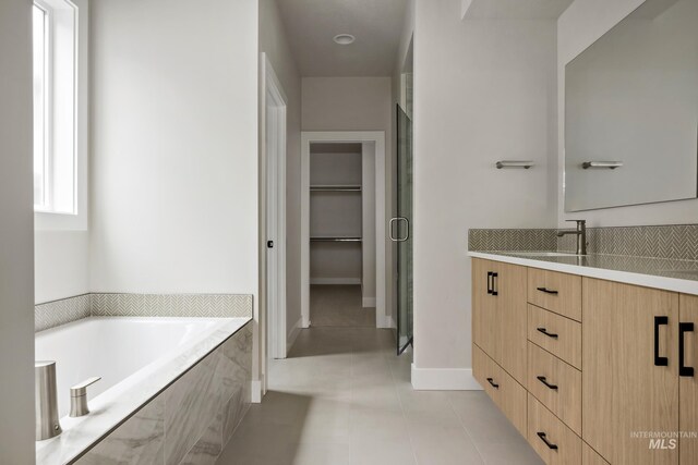 4364 N Madden Way, Meridian, ID 83646 - bathroom featuring a garden tub, vanity, tile patterned flooring, and a spacious closet