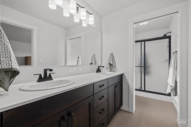 full bath featuring double vanity, a shower stall, and a sink