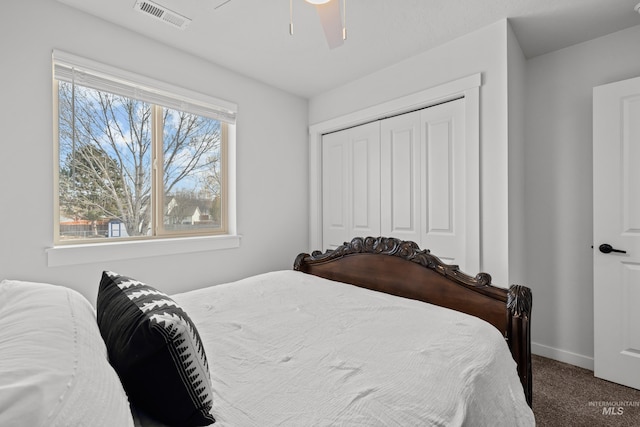 carpeted bedroom featuring visible vents, baseboards, a closet, and a ceiling fan