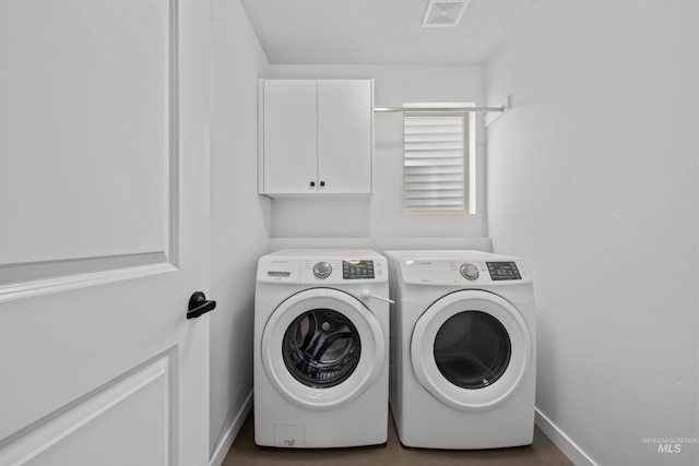 laundry room featuring visible vents, cabinet space, washer and dryer, and baseboards