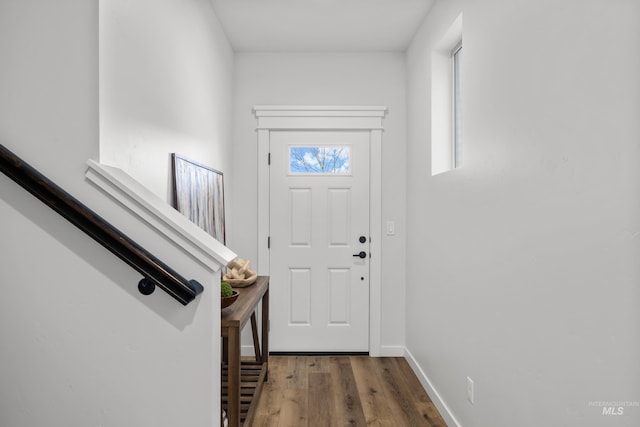 doorway with baseboards and wood finished floors