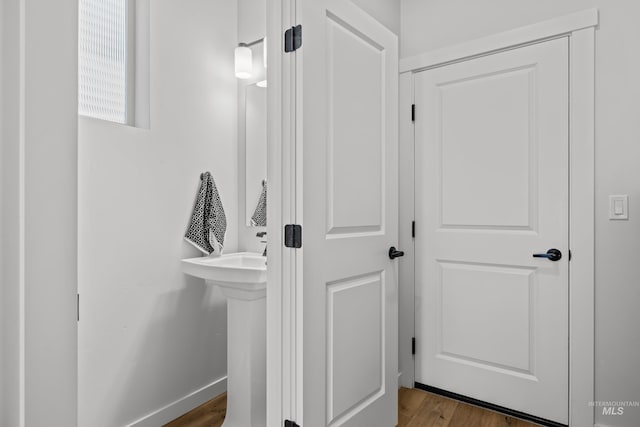 bathroom featuring a sink, baseboards, and wood finished floors