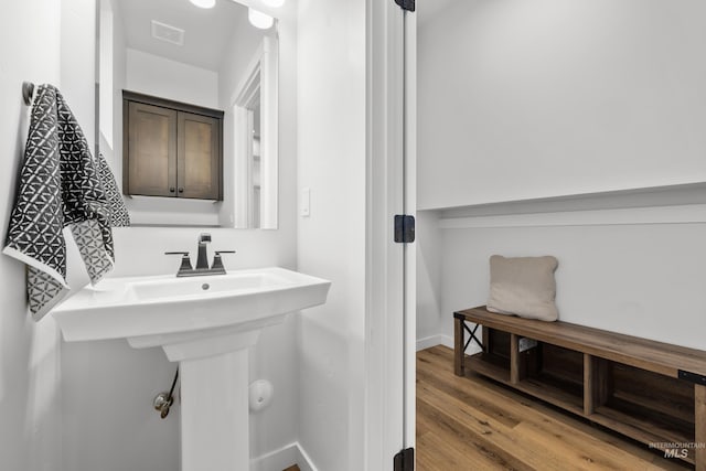 bathroom featuring visible vents, baseboards, and wood finished floors