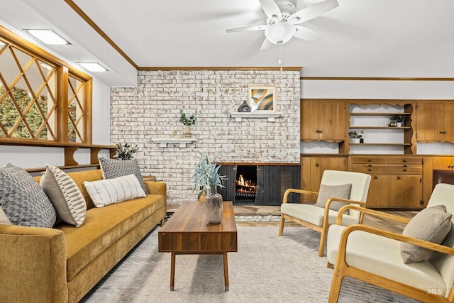 living room featuring a fireplace, ceiling fan, and crown molding